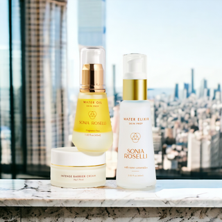 Sonia Roselli Barrier Repair Trio, including Water Oil, Water Elixir, and Intense Barrier Cream, displayed on a marble surface with a city skyline in the background