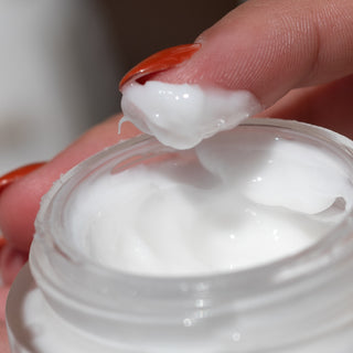 Finger dipped into open Intense Barrier Cream jar