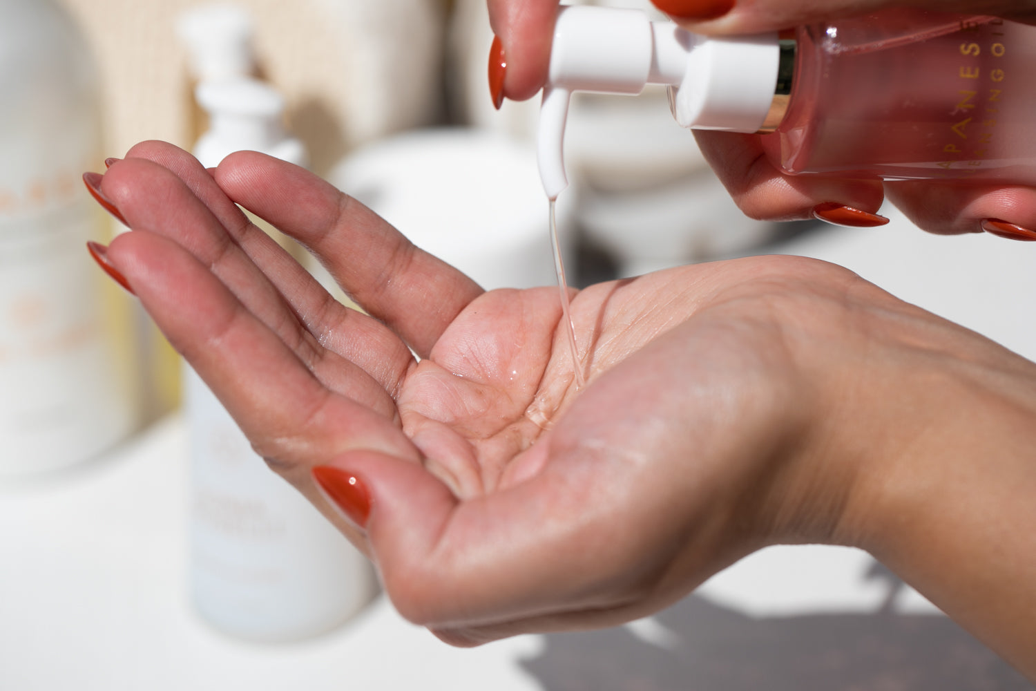 In this engaging product visual, a generous pump of Sonia Roselli Beauty's Japanese Cleansing Oil is dispensed into the palm of a hand, showcasing the ease of use and the luxurious experience of this cleansing ritual, designed to effectively remove SPF, makeup, and impurities, leaving your skin feeling pampered and clean.