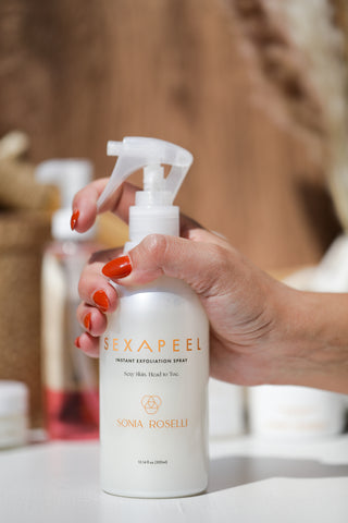 Sexapeel held in hand with red fingernails, other products in the background