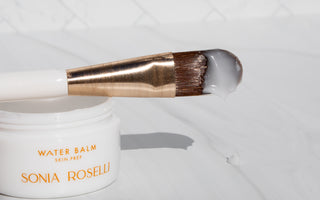 Water Balm jar with Skin Prep brush dipped in product 