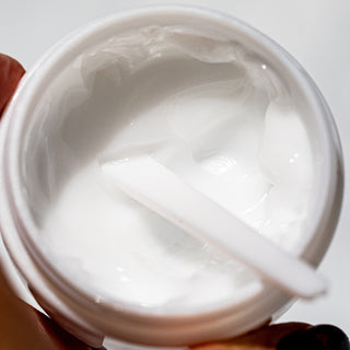 Top view of open Water Balm jar with spatula
