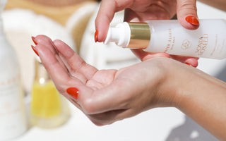 water elixir being pumped into a hand with collection of skincare in background