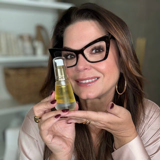 onia Roselli smiling with Water Oil hand, highlighting skin prep and hydrated skin for an ageless glow
