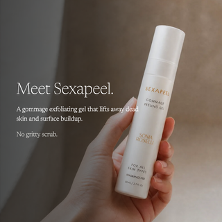 A hand holds a white cylindrical bottle of SEXAPEEL Gommage Feeling Gel against a warm beige background, with promotional text on the left.