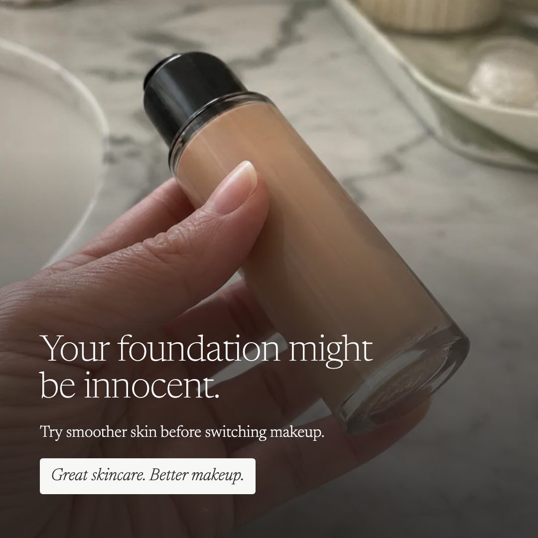 A hand holds a clear bottle of liquid foundation with beige makeup inside, against a soft marble surface background. White text on the image reads, 'Your foundation might be innocent.