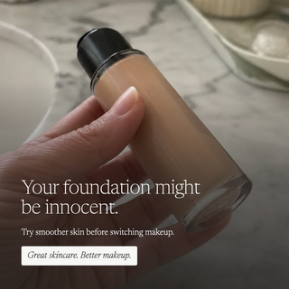 A hand holds a clear bottle of liquid foundation with beige makeup inside, against a soft marble surface background. White text on the image reads, 'Your foundation might be innocent.