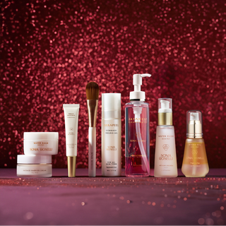 Collection of skincare products on a red glittery background