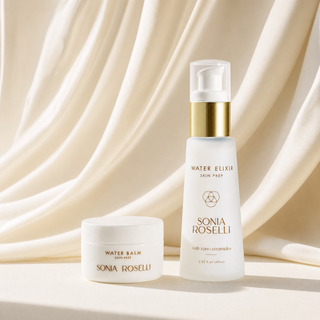 Sonia Roselli Water Elixir Skin Prep pump bottle and Water Balm jar, both in white with gold lettering, set against a draped cream satin fabric background.
