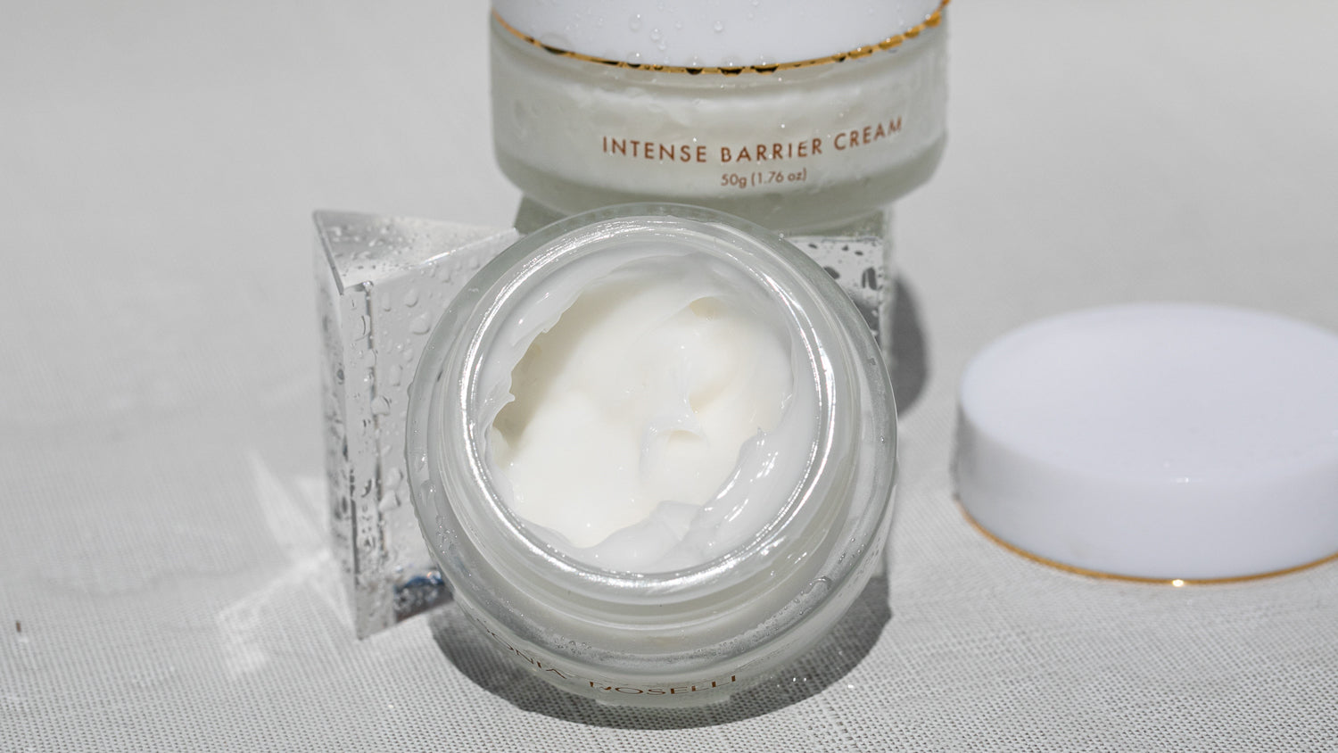 A jar of Sonia Roselli Beauty's Intense Barrier Cream takes the spotlight in this product photo. Its sleek packaging and pristine appearance convey the promise of powerful and protective skincare, offering a nourishing shield for your skin