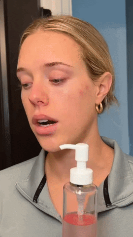 Blonde woman with a bottle of Japanese Cleansing Oil gif