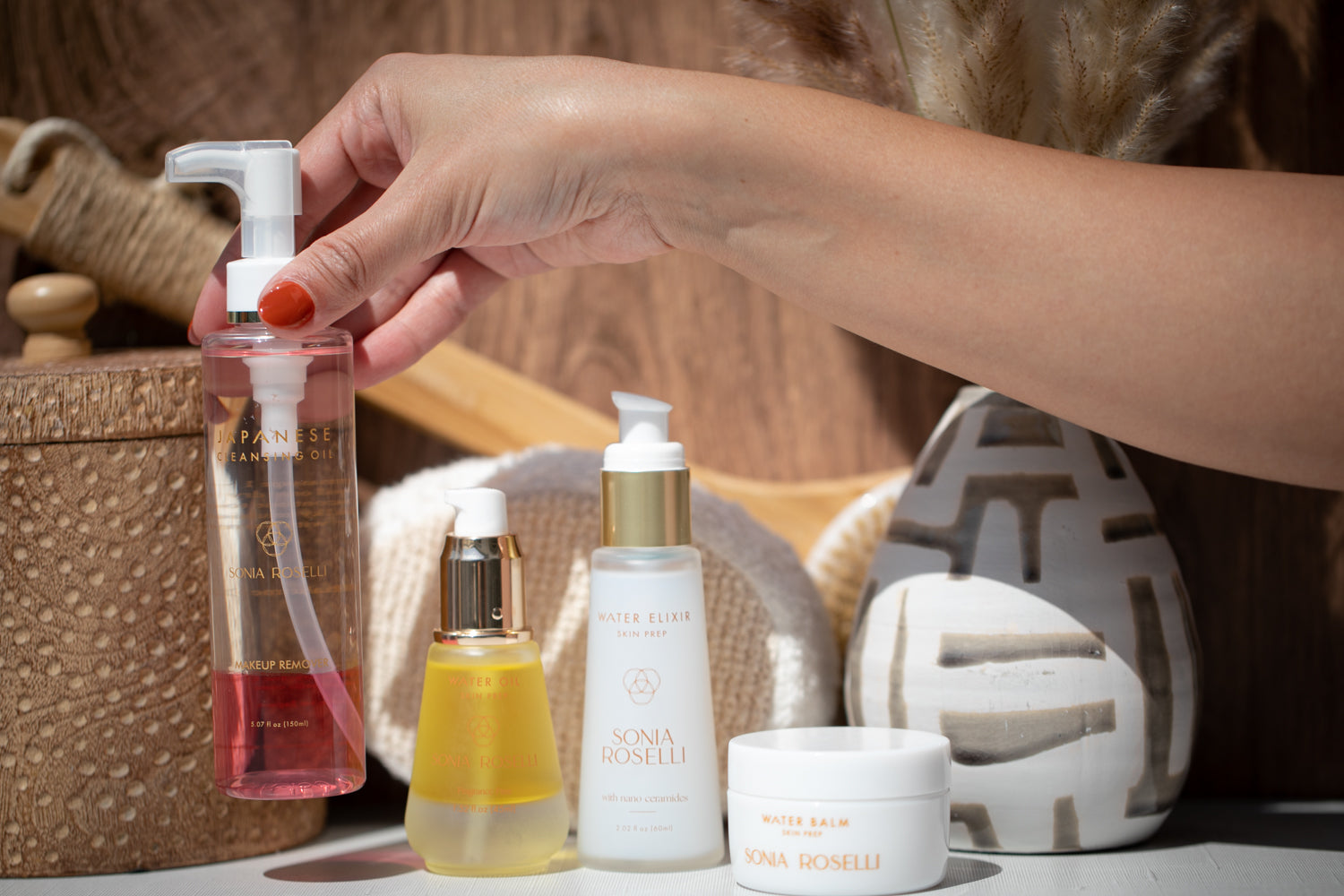 Everyday Essential Kit with the Japanese Cleansing Oil being lifted up by a hand