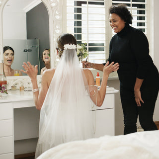 A bride happy with her makeup as she looks in the mirror.