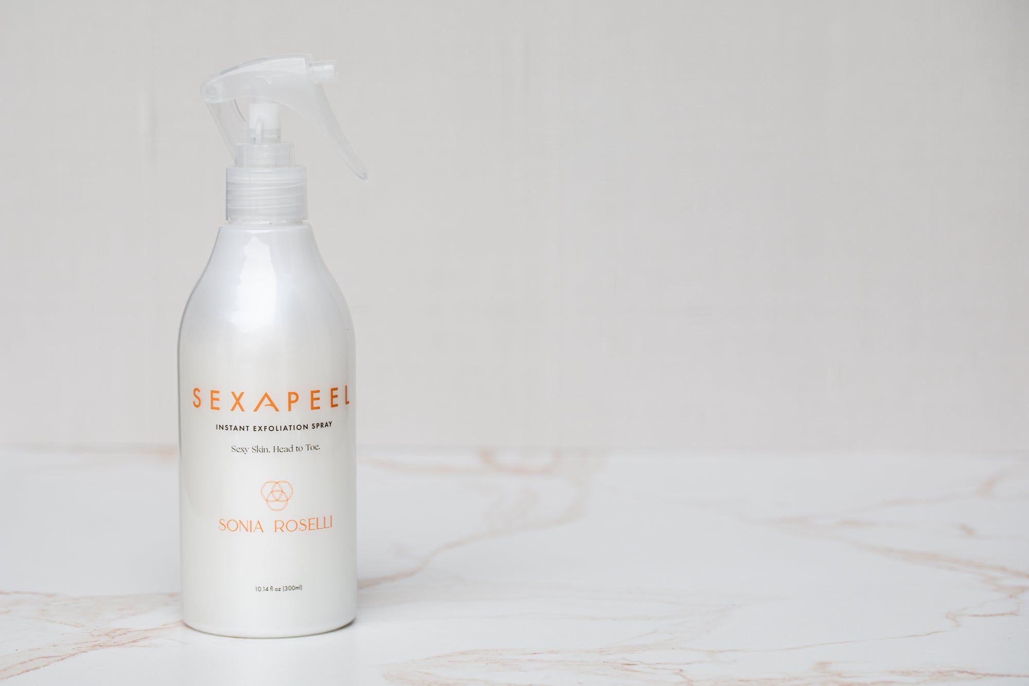 Sexapeel Spray Bottle on marble and white background