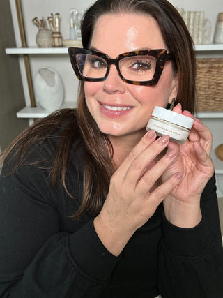 Sonia Roselli Holding a jar of intense Barrier Cream in black sweater.