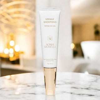 white eye cream tube on marble bathroom counter and gold lighting 