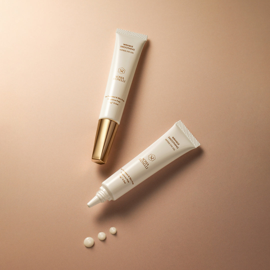 Flatlay of Sonia Roselli Wrinkle Smoothing Peptide Eye Gel showing open and closed tubes with creamy gel drops on beige background.