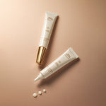Flatlay of Sonia Roselli Wrinkle Smoothing Peptide Eye Gel showing open and closed tubes with creamy gel drops on beige background.