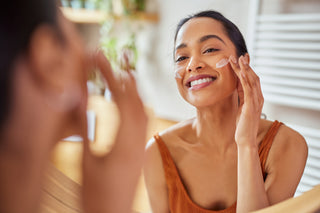 woman applying skincare in the mirror