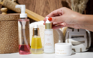 Everyday essentials collection of skincare with hand reaching for water elixir