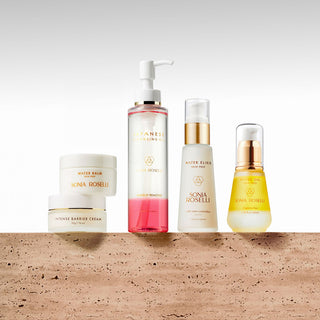 A collection of skincare products displayed on a surface, including a cleansing oil, water elixir, water oil, intense barrier cream, and water balm.Overnight Recovery Kit - 5-piece nighttime barrier repair routine with cleansing oil, serums, and moisturizers