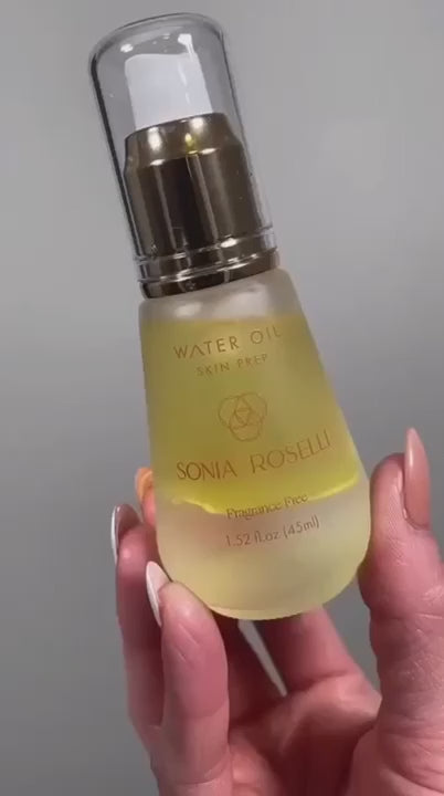 Close-up of Sonia Roselli Water Oil bottle held in hand, showing its elegant golden hue and minimalist design.