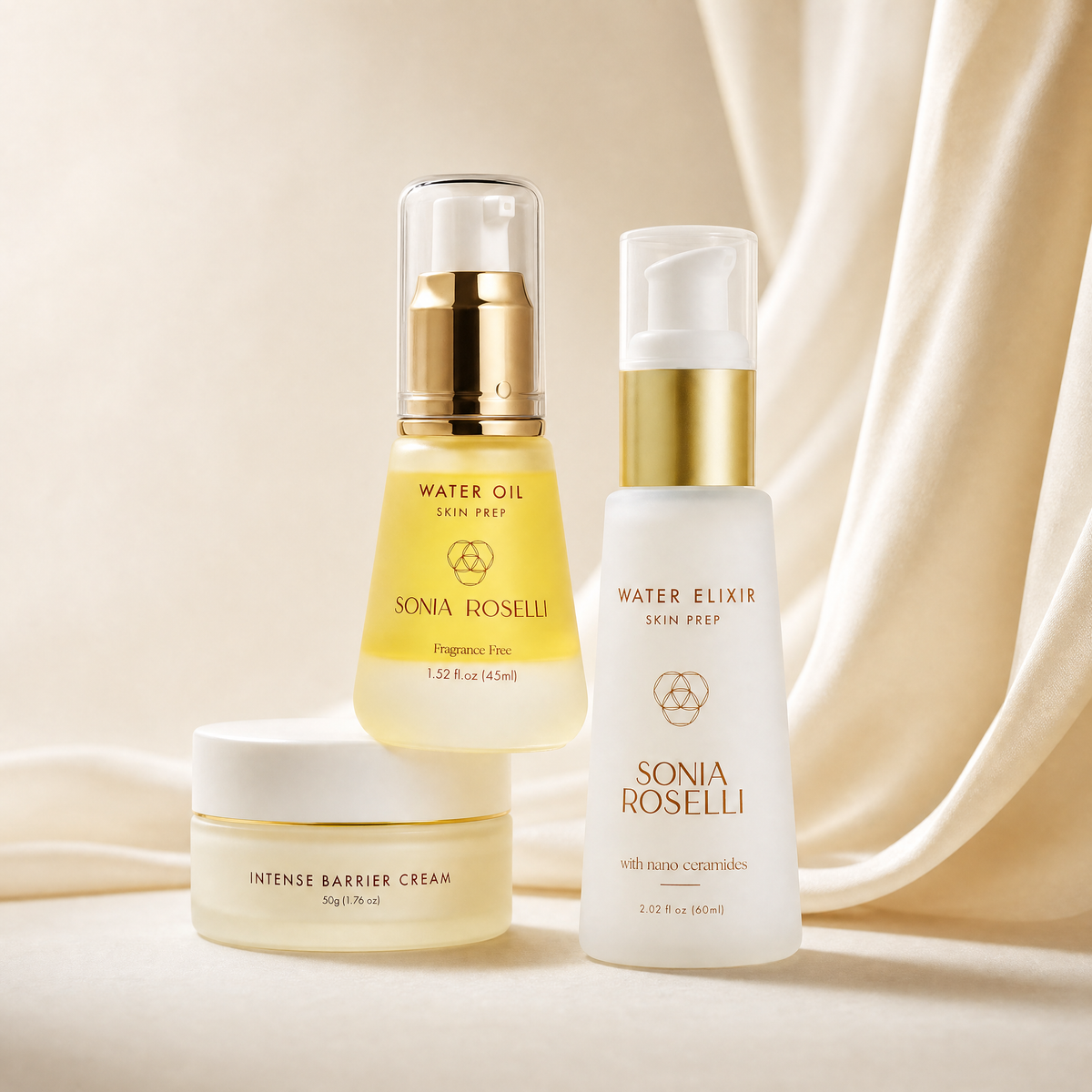 Three Sonia Roselli skincare products arranged on a soft cream fabric backdrop: a Water Oil serum bottle with a gold pump, a Water Elixir serum bottle with a white pump and gold band, and an Intense Barrier Cream jar. The products are clean, well-lit, and professionally styled.