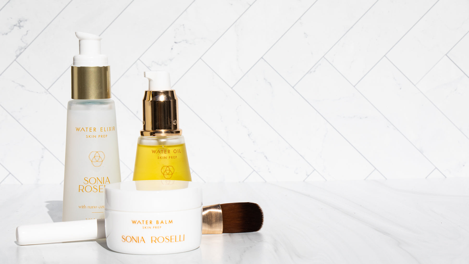 A captivating product photo showcases Sonia Roselli Beauty's Water Elixir, Water Oil, and Water Balm skincare trio, their elegant packaging glistening in soft light, promising a rejuvenating and hydrating experience for your skin.