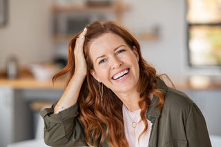 redhead smiling with great skin and army green shirt