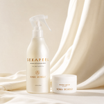 Sonia Roscelli Sexapeel Instant Estrogen Spray bottle and Water Balm jar set, styled on draped cream-colored fabric.