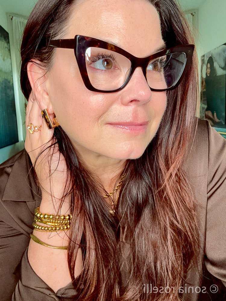 Close-up selfie of Sonia Roselli, a 57-year-old Licensed Esthetician, showing her natural skin texture and glow without filters or heavy retouching.