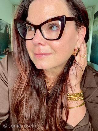 Close-up selfie of Sonia Roselli, a 57-year-old Licensed Esthetician, showing her natural skin texture and glow without filters or heavy retouching.