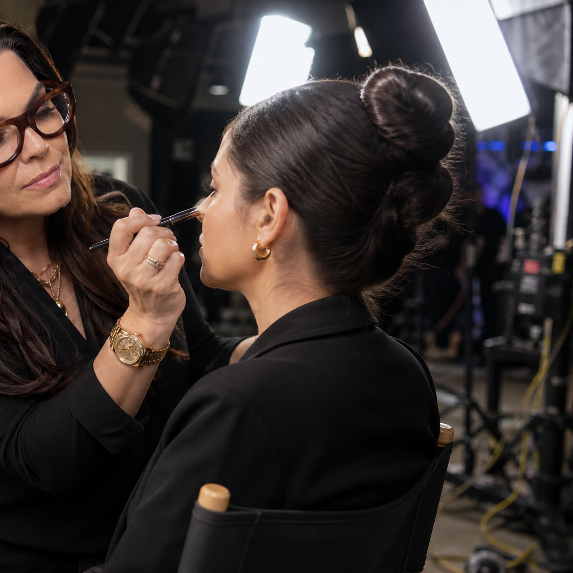 Makeup artist applying makeup to a model on a film set.