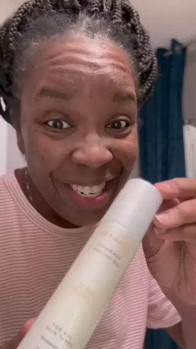 Woman smiling and holding a bottle of Sonia Roselli Beauty Sexapeel Gommage Peeling Gel in a skincare video.