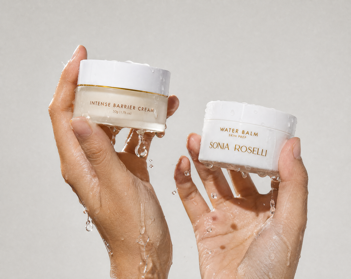 Two hands holding white cosmetic jars with water droplets, featuring Sonia Roselli Water Balm and Intense Barrier Cream against a light gray background.
