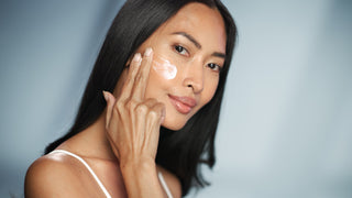 asian woman applying skincare on face
